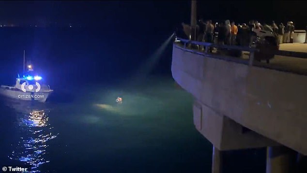 A spotlight is focused on the woman, who was in the water after falling into the surf