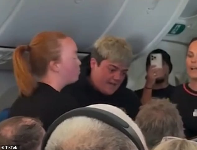 Footage shows a woman standing in the aisle of flight JQ43 and shouting at passengers and staff