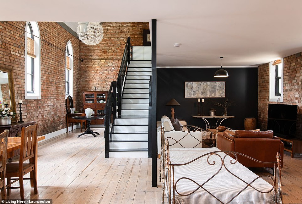 Inside, the trendy black and white color palette and modern luxury complement the original details, from the exposed brick walls to the Gothic arched windows