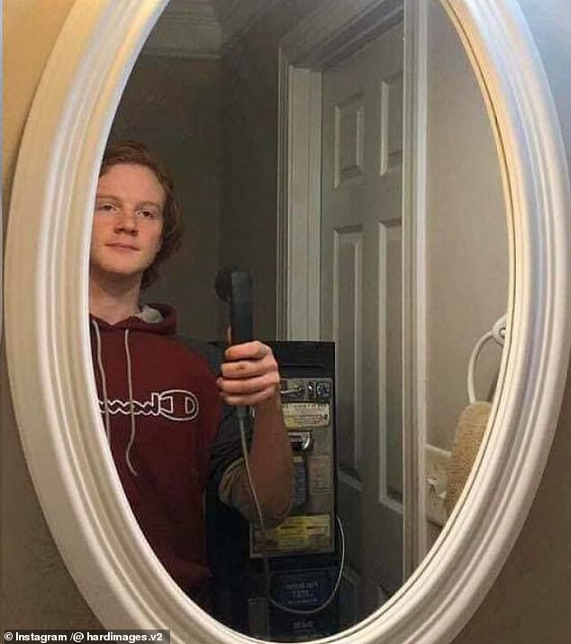 This boy has simulated taking a selfie with an old-fashioned phone in the bathroom mirror