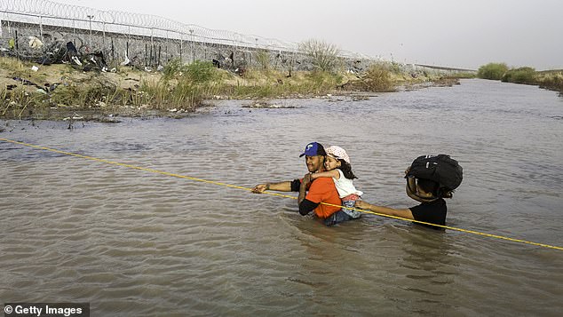 In an aerial view, immigrants wade through the Rio Grande as they cross the U.S.-Mexico border to seek asylum on March 13