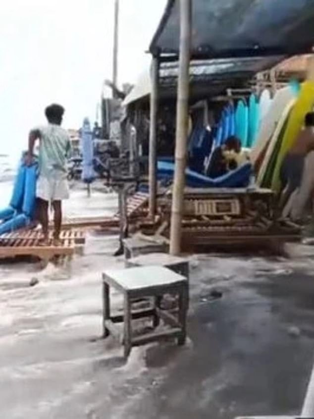 A video has emerged of the wild weather at Canggu Beach in Bali.  The footage shows a man desperately trying to save items being swept away from beach stalls