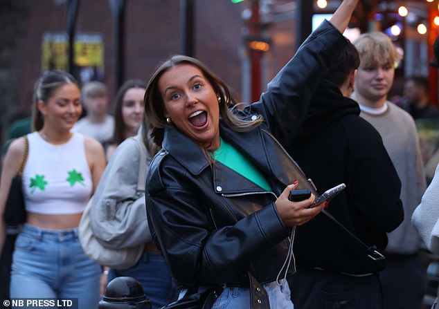 LEEDS: An excited woman poses for a photo as revelers in shamrock-themed outfits enjoy the festivities