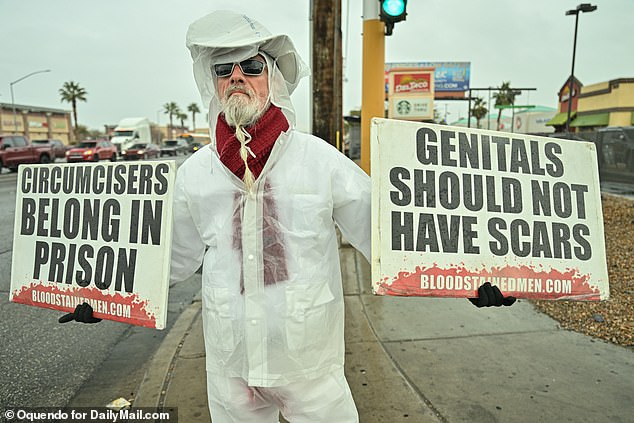 An anti-circumcision activist holds banners in Las Vegas, US, including one calling for the jailing of doctors who perform the procedure