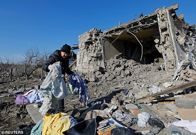 A local resident gathers belongings in the ruins of a destroyed house on the outskirts of Makiivka (Makeyevka) in the Donetsk region of Ukraine, as the Pentagon has found a way to send more weapons to the war-torn country