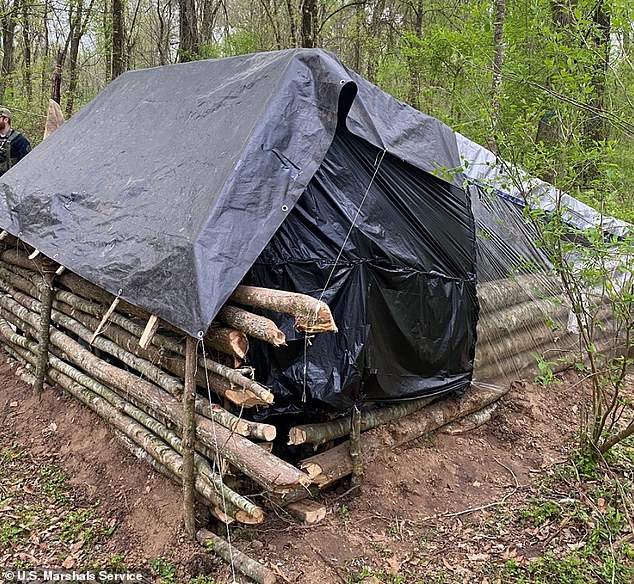 The shelter was made of branches stacked on top of each other and covered with garbage bags and tarpaulin