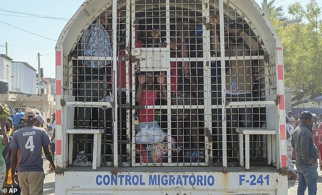 People detained for deportation to Haiti stand in a police truck on the border bridge connecting Dajabon, Dominican Republic, with Haiti, Monday, March 18, 2024