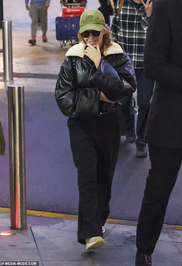 Kylie looked around coyly as she left Sydney airport