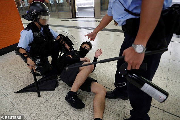 A protester against the extradition bill is held by a riot police officer during a protest at the Po Lam Mass Transit Railway (MTR) station in Hong Kong, China, September 5, 2019