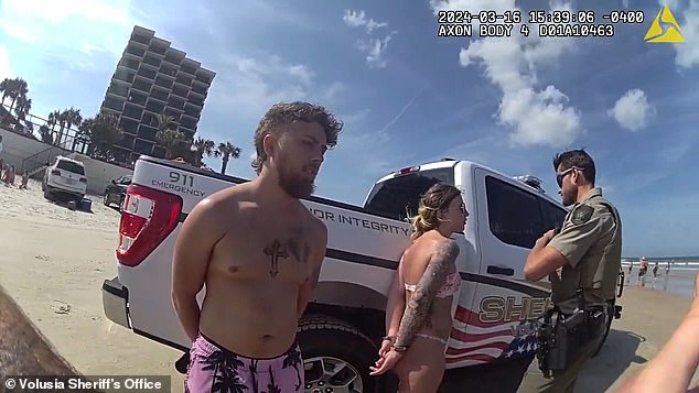 The couple is seen handcuffed on the beach by the officer before Stephens took off running