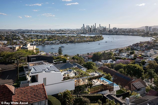 Proposed renovations to the house (center) would see the transparent paneling replaced with opaque materials that could block their millionaire neighbors' view of the Brisbane River