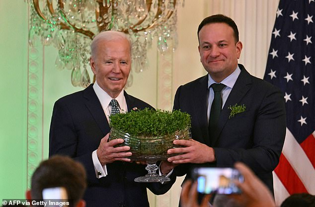 Irish Prime Minister Leo Varadkar (R) presents a bouquet of shamrocks to US President Joe Biden during a St. Patrick's Day celebration in the East Room of the White House in Washington, DC, on March 17, 2024