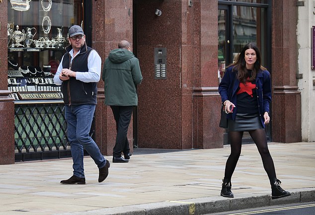 She wrapped herself in a navy blue jacket and added black lace-up boots and a matching handbag to her ensemble