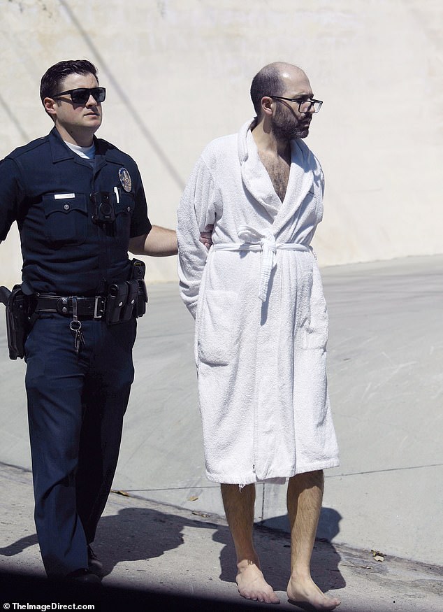 The technology entrepreneur looked gloomy when he was approached by officers on the sidewalk in front of his house