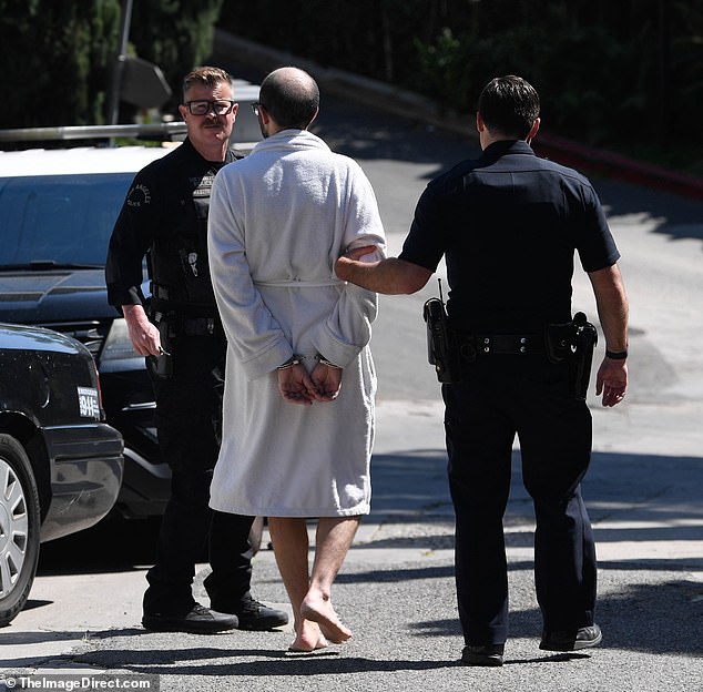 The star was led away in handcuffs while still in a bathrobe