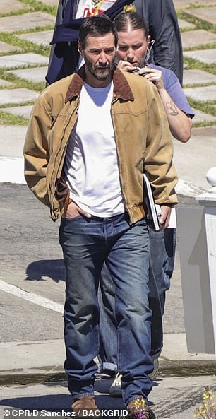 The actor looked casual in jeans and a white T-shirt with a brown jacket