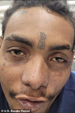 Arrested Colombian man is seen in a close-up photo with a teardrop tattoo under his eye and a money bag tattoo between his eyebrows