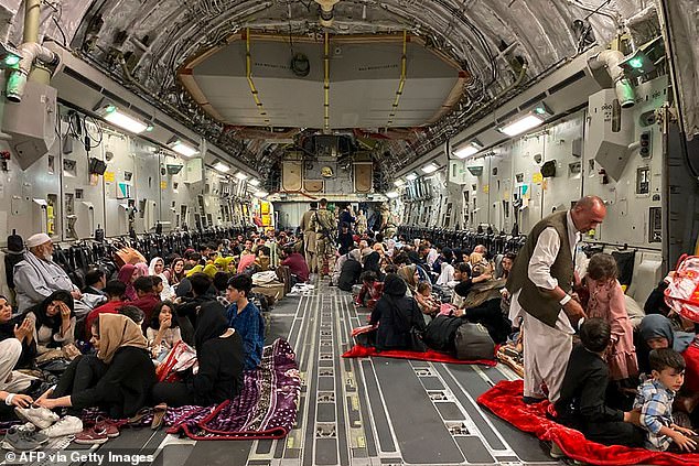 Afghan people sit in a US military plane to leave Afghanistan, at the military airport in Kabul on August 19, 2021 after the Taliban's military takeover of Afghanistan