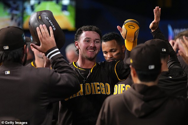 Jackson Merrill #3 of the San Diego Padres celebrates with teammates after scoring a run