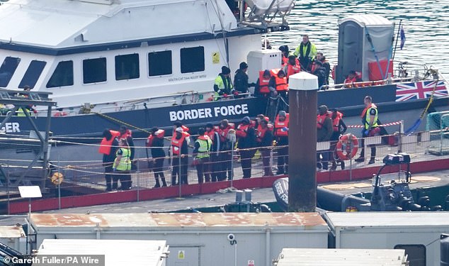 People believed to be migrants are seen being taken by Border Force to Dover, Kent, yesterday morning