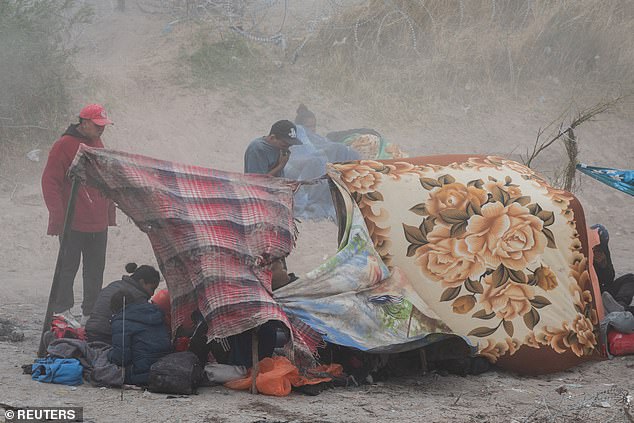 A dust storm blows through a migrant camp on the U.S. side of the Rio Grande as migrants await the fate of a new border law that could make it harder for them to enter through Texas