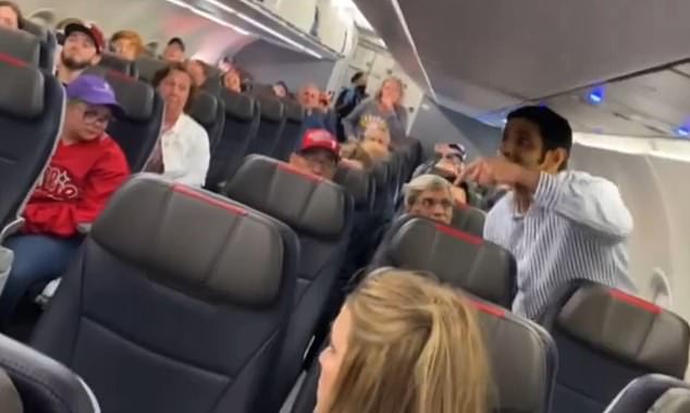 The passenger, wearing a white and blue striped button-down, caused a major scene during the flight while sitting on the runway and experiencing a 30-minute delay