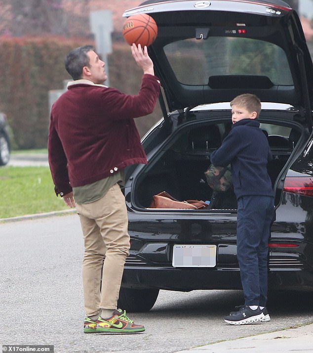 The Argo Oscar winner was spotted spinning the basketball on his fingers in front of the open hatch of his black Mercedes