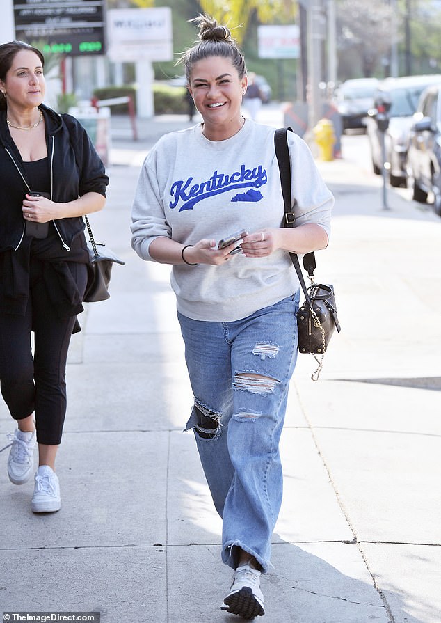 Cartwright, who is originally from Winchester, Kentucky, wore a light gray crew neck with her home state on her chest and distressed light wash jeans with rips on her knees and thighs.