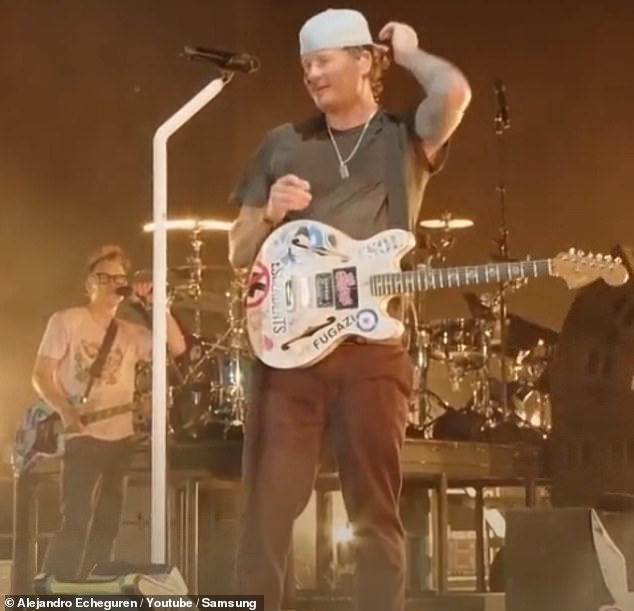 But in a flourish of showmanship, Tom (center) then returned to his spot at center stage and completed the performance with his bandmates Travis Barker and Mark Hoppus.