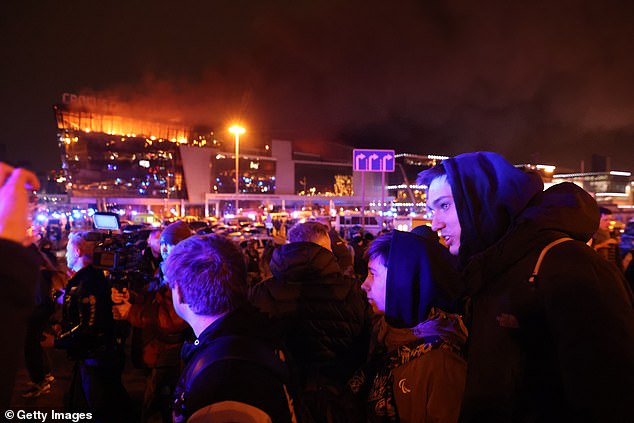 People gather at Crocus Town Hall.  Early reports indicated that at least 60 people were killed and many more injured when several gunmen opened fire at the site