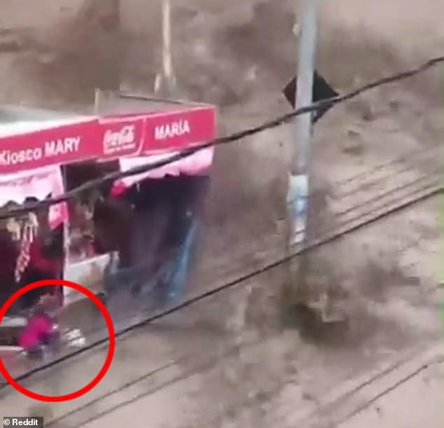 A child was seen falling to the ground and then being picked up by an adult moments after water poured over the wall of a reservoir during a rainstorm in La Paz, Bolivia, on Wednesday.