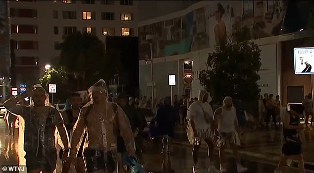 The Ultra Music Festival in Bayfront Park closed early Friday evening, forcing Spring Break clubgoers to walk home through flooded streets (pictured)