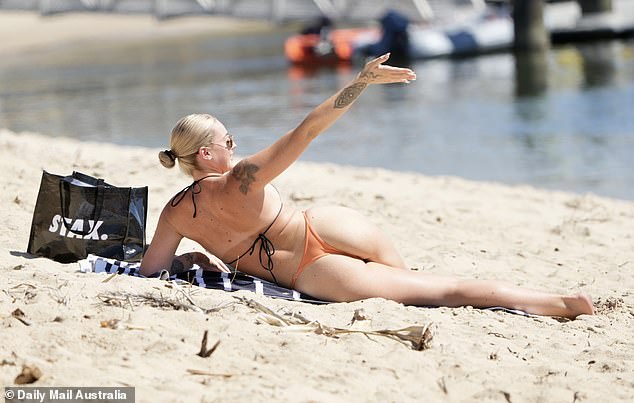 Tori showed off her incredible figure in a very skimpy orange and black two-piece thong as she lay down on a towel and soaked up the rays, waving to Jack - who was swimming