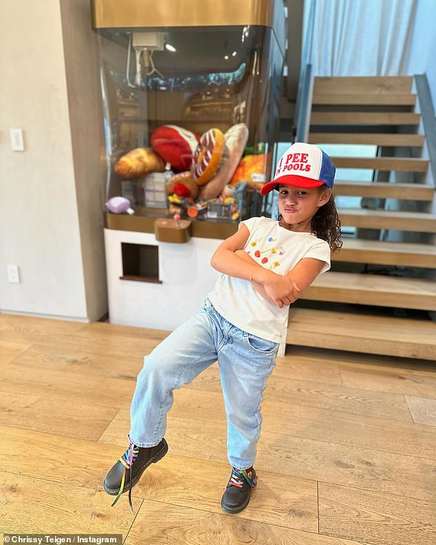 The first photo showed off their eldest daughter Luna's sassy personality, as the seven-year-old posed with her arms crossed while wearing a hilarious baseball cap that read: 'I pee in swimming pools'