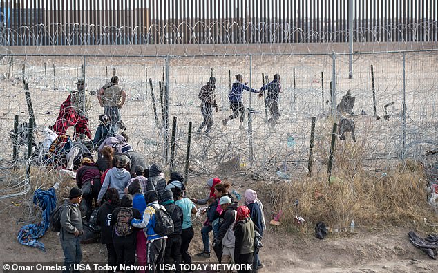 Migrants breach the infrastructure set up by the Texas National Guard on the Rio Grande in El Paso, Texas on March 21, 2024