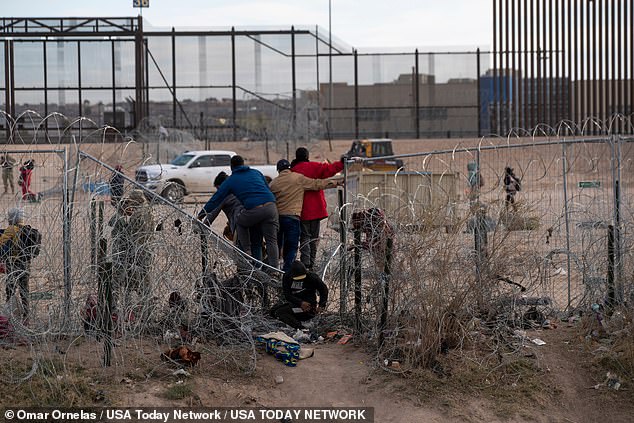 Migrants stand on infrastructure breached by migrants on the Rio Grande in El Paso, Texas on March 21, 2024