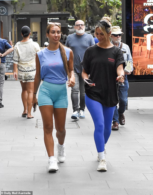 She wore a pair of white sneakers and had sunglasses on her head