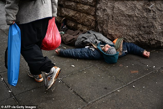 A person lies on the street in the Old Town Chinatown neighborhood of downtown Portland