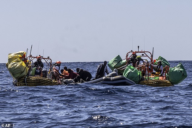 Migrants were helped to evacuate a partially deflated rubber boat earlier this month.  File image