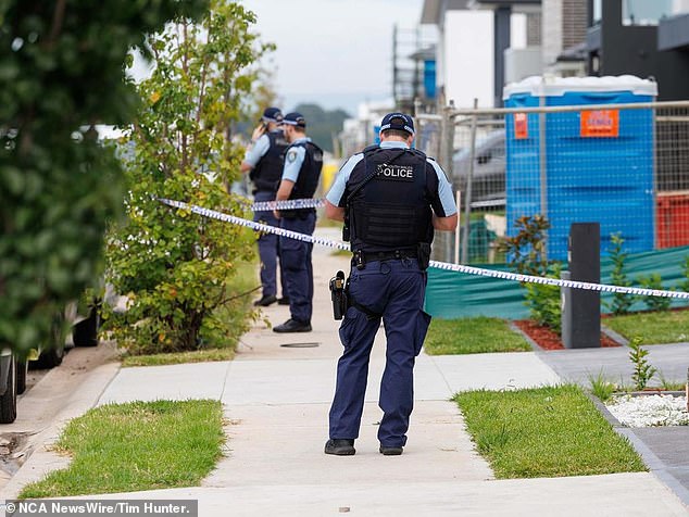 Police arrested Fletcher shortly after he allegedly crashed his car into a parked vehicle and charged him with murder (photo, police at Fletcher's home)