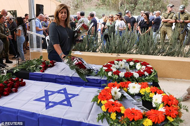 More than five months after the Hamas terrorist attacks of October 7, the kibbutz with almost 800 inhabitants is a ghost town.  (Mourners at funeral for victims killed in Kfar Aza)