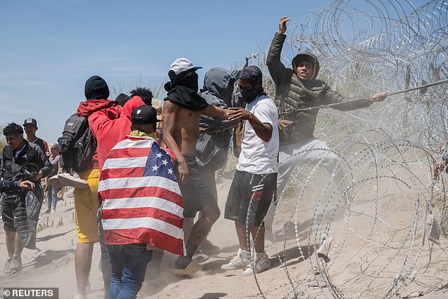 Another group of migrants entering Texas are trying to tear down the barbed wire between them and the US