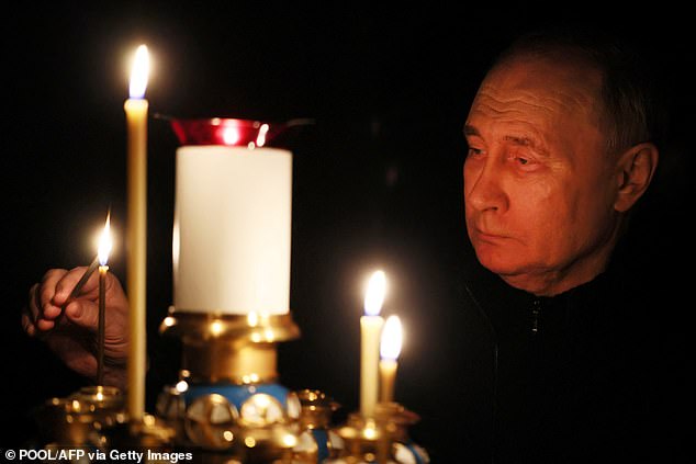 Vladimir Putin lights a candle during his visit to a church at the Novo-Ogaryovo state residence on March 24, as the country celebrates a national day of mourning after the massacre