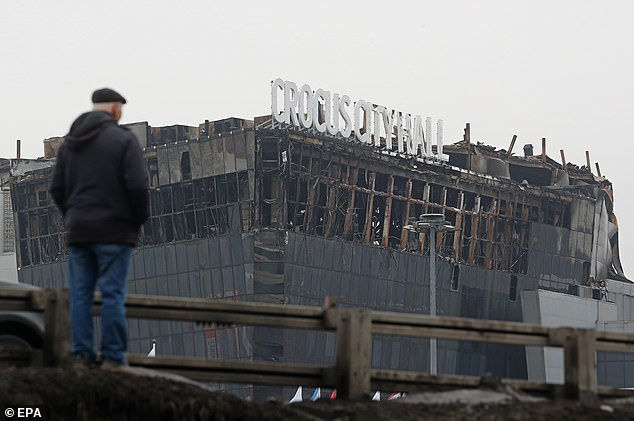 A person looks at the Crocus City Hall concert venue after a terrorist attack