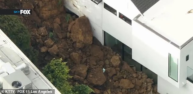 As the ground gave way, clumps of dirt have piled up the sides of the expensive homes, blocking the view from the windows