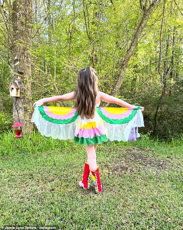 In other photos, she showed off her rainbow-colored dress with parrots on the front and wings.  Ivey also wore red and pink cowboy boots and posed with her father in two of the images