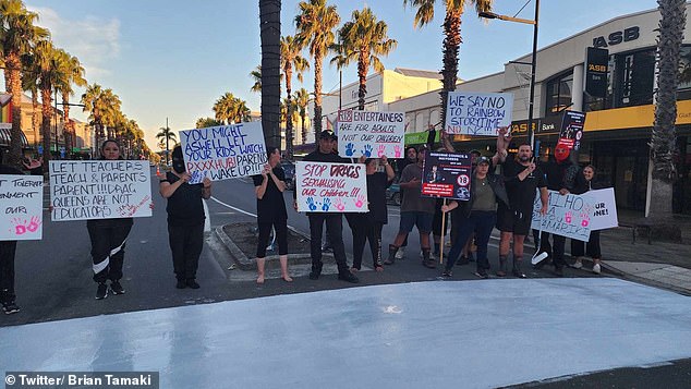 Church members block the intersection by holding up signs across the road