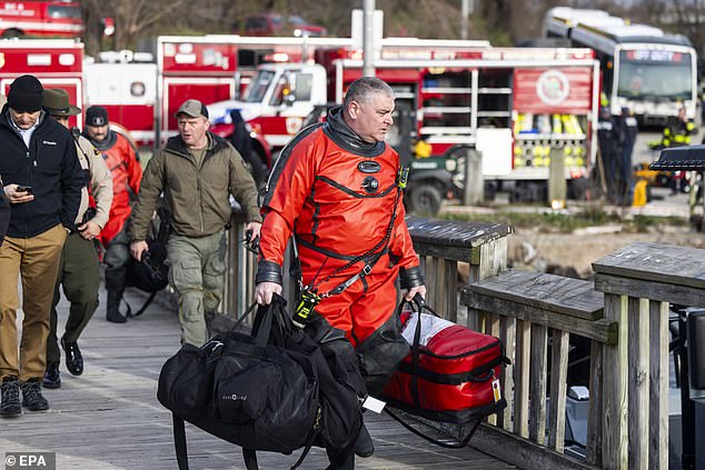 Rescue personnel gather on the banks of the Patapsco River