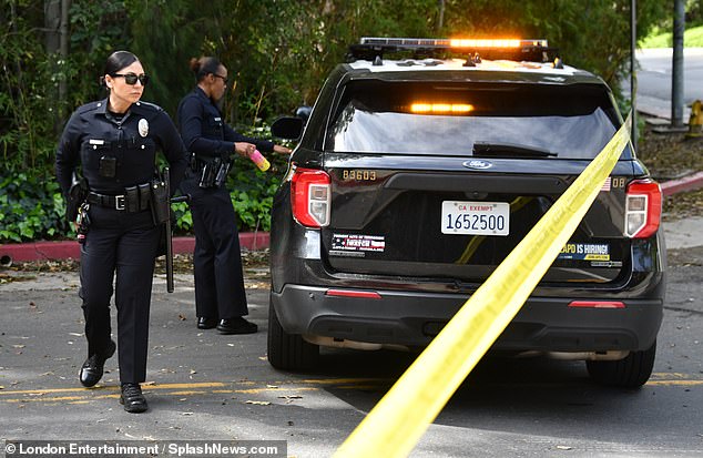 Police officers monitor the scene at Diddy's Holmby Hills mansion