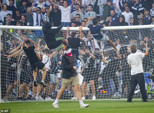 The A-League match between Melbourne Victory and Melbourne City in December 2022 was abandoned after fans stormed the pitch and hooligans climbed the goalposts (pictured)